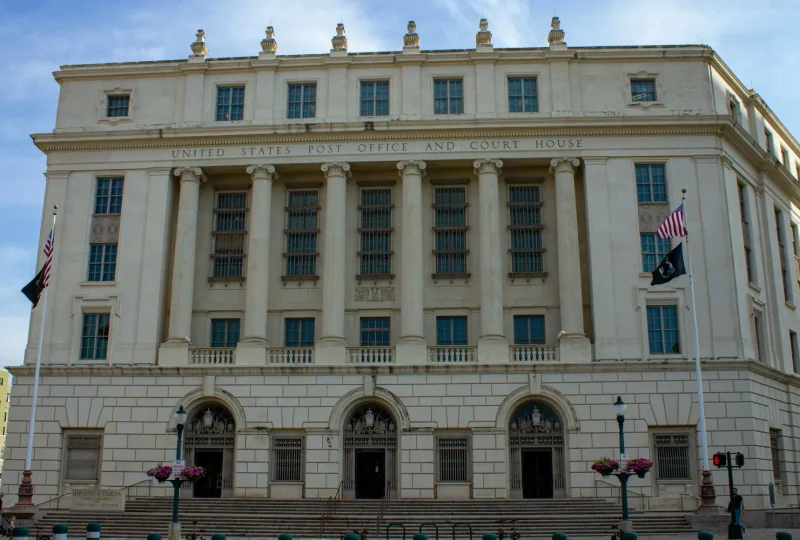 Stone courthouse building with flags flying out front