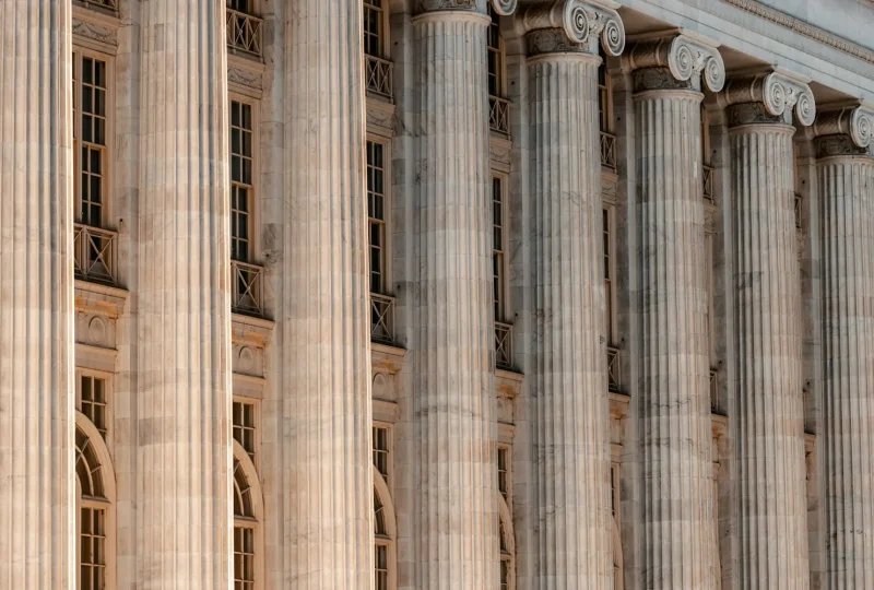 Row of tall stone columns along a courthouse facade
