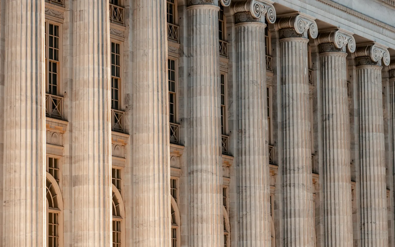 Row of tall stone columns along a courthouse facade