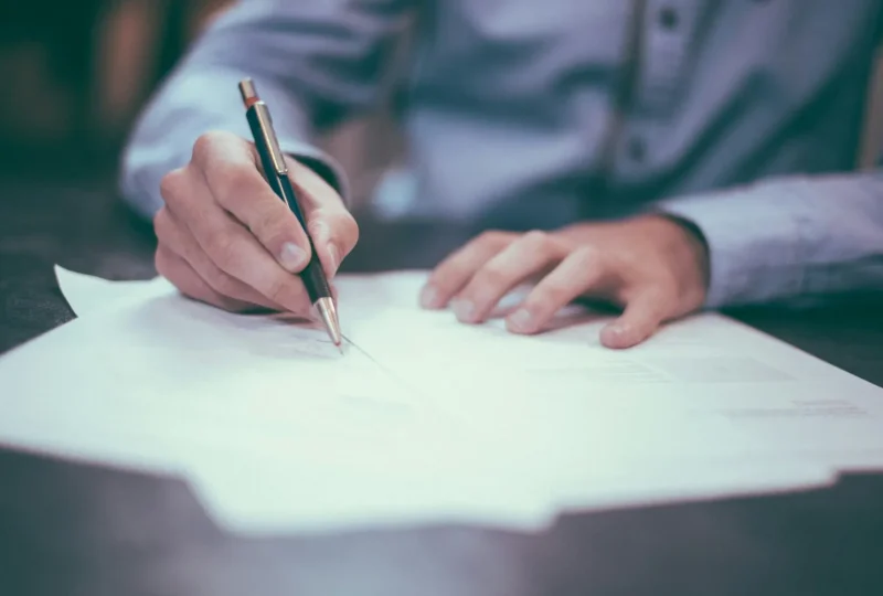 Person writing notes on paper at a desk