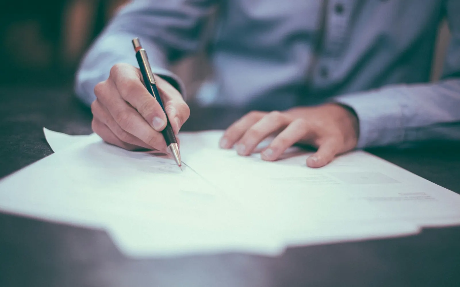 Person writing notes on paper at a desk