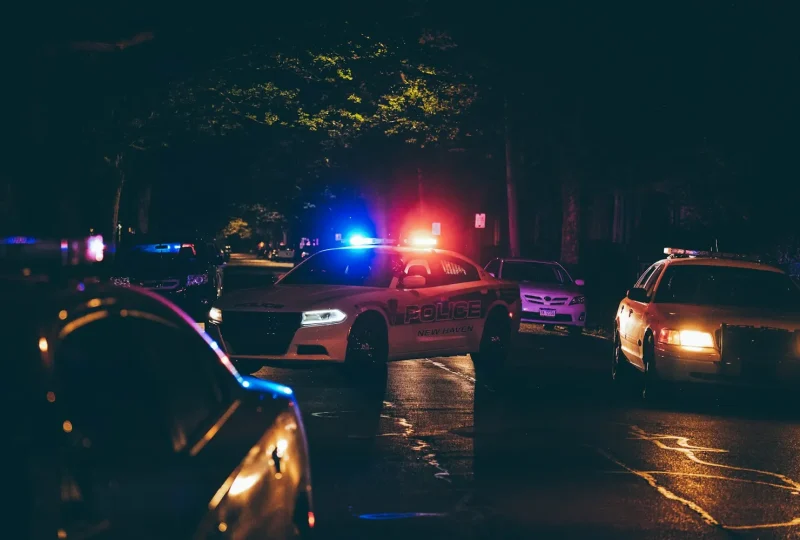 Police cars with emergency lights on a residential street at night