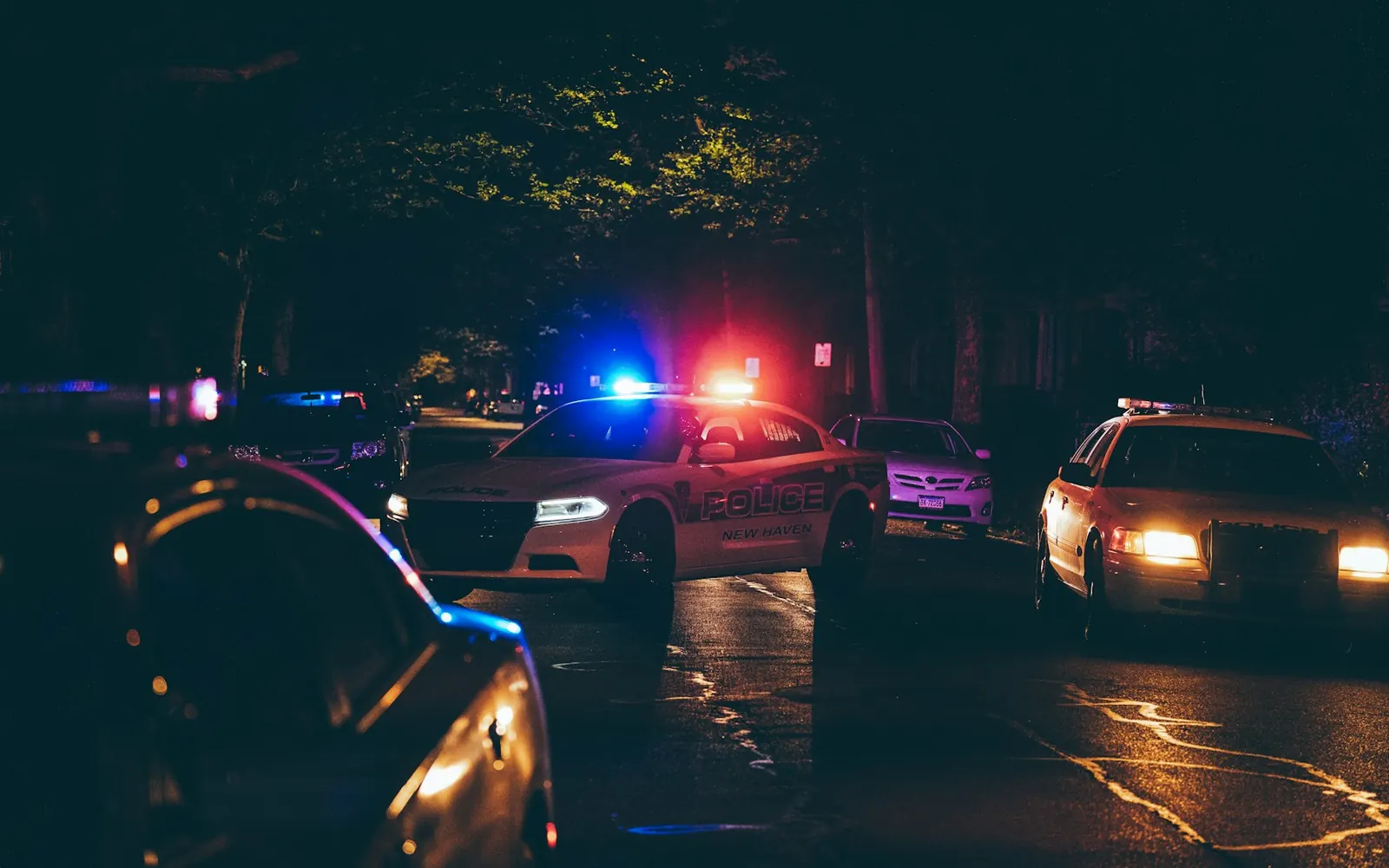 Police cars with emergency lights on a residential street at night