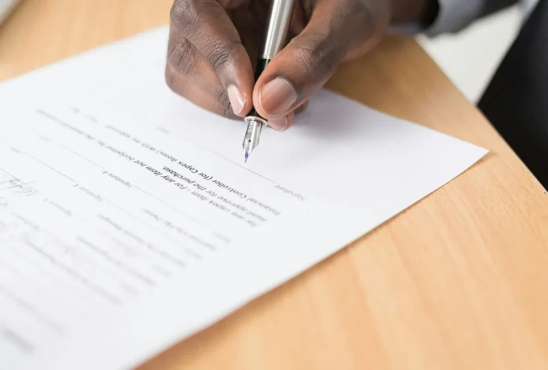 Hand signing a printed document with a pen
