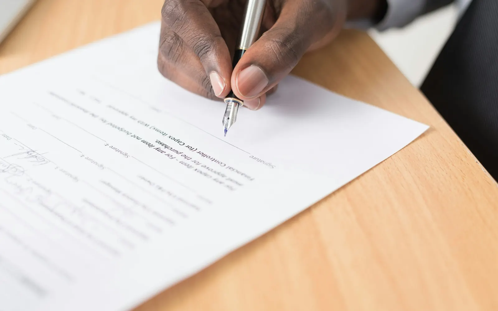 Hand signing a printed document with a pen