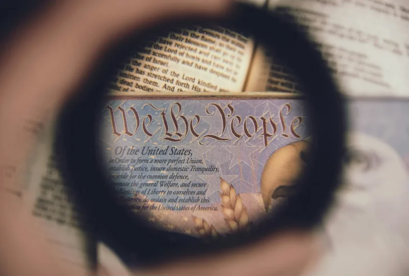Magnifying glass over the words “We the People” in the U.S. Constitution